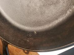 an old frying pan sitting on top of a wooden table