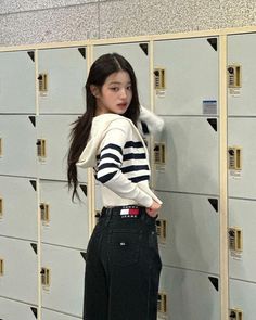 a young woman standing in front of lockers