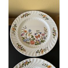 two white plates with floral designs on them