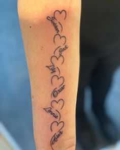 a woman's arm with many hearts on it and the word love written in cursive writing