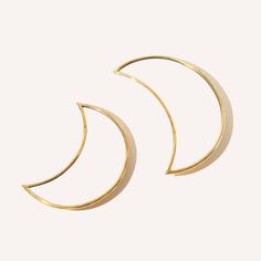 two gold crescent earrings against a white background, one is half closed and the other half open