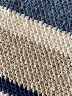 a close up view of a blue, beige and white blanket