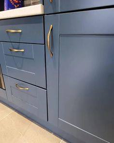 a kitchen with blue cabinets and gold handles