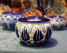 three blue and white vases sitting on top of a table