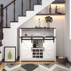 a white cabinet with wine glasses and bottles on it in front of a stair case