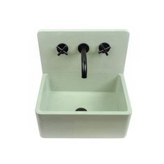 a white sink with two black faucets on the front and one in the back