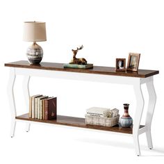 a console table with books and pictures on it