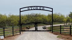 a gated entrance to a dirt road with a sign on it that says stocker