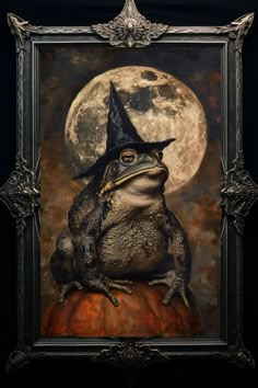 a frog wearing a witches hat sitting on top of a pumpkin in front of a full moon