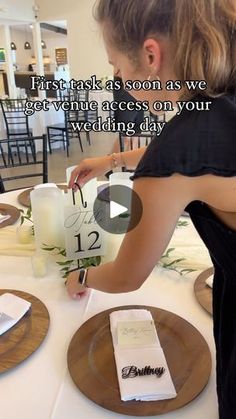 a woman is setting the table for a wedding ceremony with candles and napkins in front of her