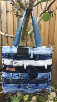 a bag made out of jeans hanging from a tree