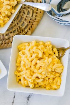 two bowls filled with macaroni and cheese on top of a table