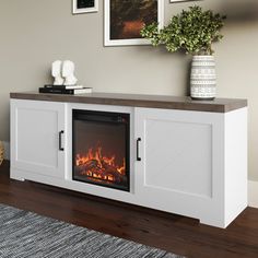 a white entertainment center with a fireplace in it