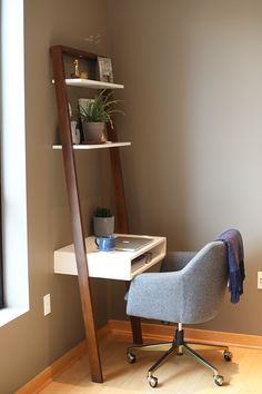 a chair and desk in a room with a ladder leaning up against the wall next to it