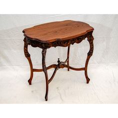 an old wooden table with carvings on the top and bottom, sitting against a white background