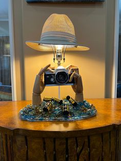 a lamp that is sitting on top of a table with a camera in front of it