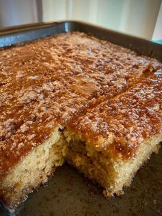 a close up of a cake in a pan with one slice cut out and the other half eaten