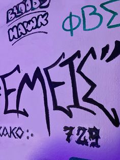 graffiti written on the side of a wall in purple and green colors with black letters