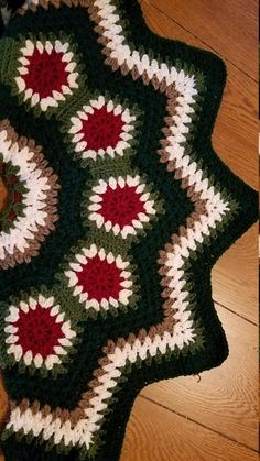 a crocheted granny blanket on the floor