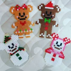 three cross stitch teddy bears are on a white background and one bear is wearing a santa hat