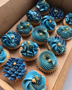 a box filled with blue cupcakes covered in frosting