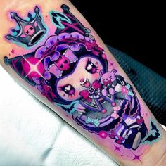 a colorful tattoo on the arm of a girl with a crown and stars in her hair