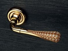 a close up of a gold handle on a wooden door with diamond accents in the center