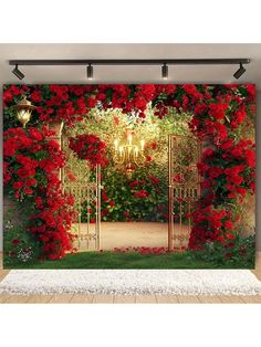 red roses are growing on the side of a wall with an open gate in front