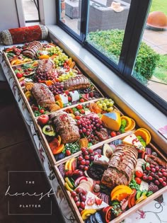 an assortment of meats and vegetables on display in a window sill