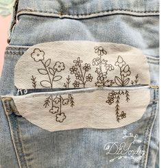 the back pocket of a pair of jeans with embroidered flowers on them