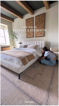 a woman sitting on the floor in front of a bed