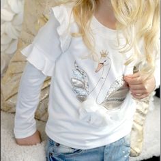 Baby Sara Girls L/S Cream Ruffle Top W/ Swan Print Applique Playful Long Sleeve Tops With Ruffles, Playful White Fitted Top, Playful Fitted White Top, Cute White Tops For Fall, Long Sleeve Ruffled T-shirt For Summer, Cute White Shirt For Fall, Cute White Fall Shirt, Cute White T-shirt With Ruffles, Trendy Fringe