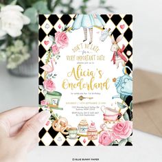 a woman holding up a black and white card with alice's wonderland theme on it