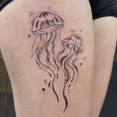 a woman's thigh with a black and white jellyfish tattoo on it