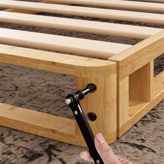 a hand is holding the handle on a bed frame