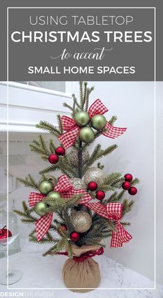 a small christmas tree sitting on top of a table next to a vase filled with ornaments