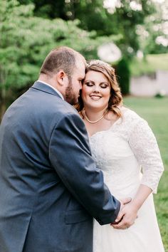 a bride and groom pose for a photo in front of the trees at their wedding