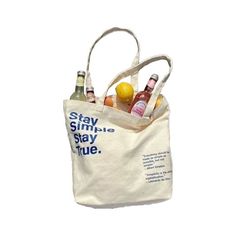 a tote bag filled with bottles of alcohol sitting on top of a white table