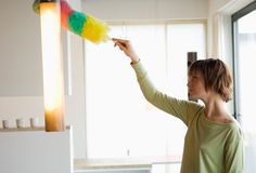 a woman is painting the wall with colorful paint and a yellow pole in front of her