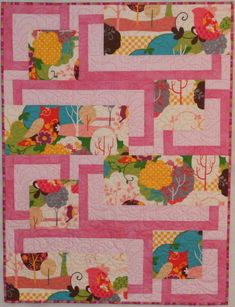 a pink quilt with different designs on it