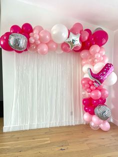 the balloon arch is decorated with pink, white and silver balloons