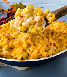 a bowl filled with macaroni and cheese on top of a blue tablecloth