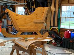 a man working on a wooden chair in a garage