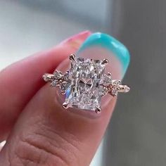 a close up of a person holding a ring with a diamond in it's center