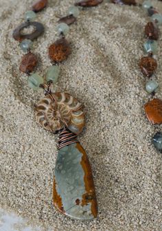 I love all types of Jasper because of the unexpected patterns found amidst the fabulous, naturally occurring colors. I found this large green and brown piece of Jasper at the Tucson Gem Show one year and it sat there in my collection until, one day, I paired it with an Ammonite fossil.  Voila!  A dramatic pendant was born!  Because of its size, I thought it needed to be showcased on a very long strand that you could just toss over your head.  I used oxidized copper wire to connect each link in t Types Of Jasper, Handmade Statement Necklace, Tucson Gem Show, Diy Jewellery Designs, Boho Necklaces, Beaded Jewelry Necklaces, Diy Necklaces, Ammonite Fossil, Gem Show