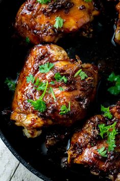 chicken thighs in a skillet with garnishes and parsley on top