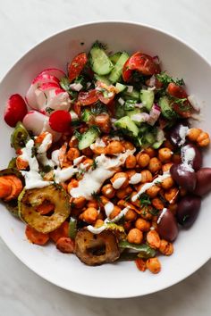 a white bowl filled with different types of vegetables