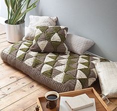 a living room with a couch, coffee table and potted plant on the floor