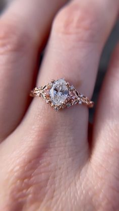 a close up of a person's hand with a diamond ring on their finger