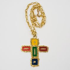 This is part of Chairish’s Costume Jewelry assortment.  This gorgeous Mercedes Robirosa Paris couture pendant necklace features an oversized gilt metal all-textured and pierced cross pendant ornate with enamel in red, green, blue, and yellow colors. The heavy gilded metal chain has a hook closing clasp and chain for length flexibility. The signature is engraved underside of the pendant: Mercedes Robirosa. Measurements: Necklace total length is 31.10 in (79 cm) - drop is 18.50 in long (47 cm) - p Enamel Cross, Paris Couture, Chanel Couture, Accessories Jewelry Necklace, Cross Pendant Necklace, Blue And Yellow, Metal Chain, Yellow Color, Cross Pendant